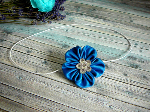Čelenka s modrou květinou.