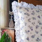 Polštář s motivem modrých růžiček , lemovaný krajkou šíře 45 mm, včetně výplně.