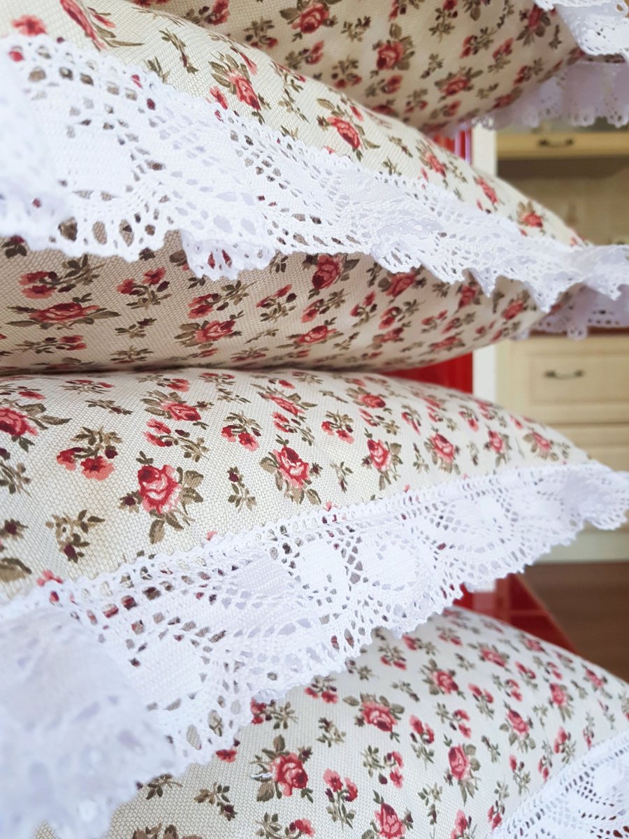 Sedák s motivem růžiček, lemovaný krajkou šíře 45 mm včetně výplně s úvazy.