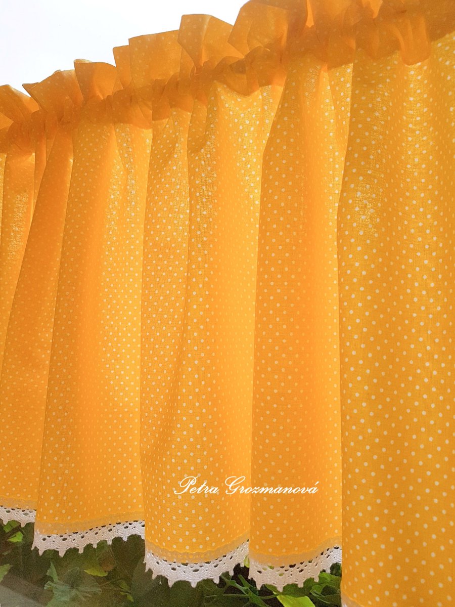 Záclonka ve žlutém provedení s motivem bílých puntíků, lemovaná bílou krajkou šíře 45 mm
