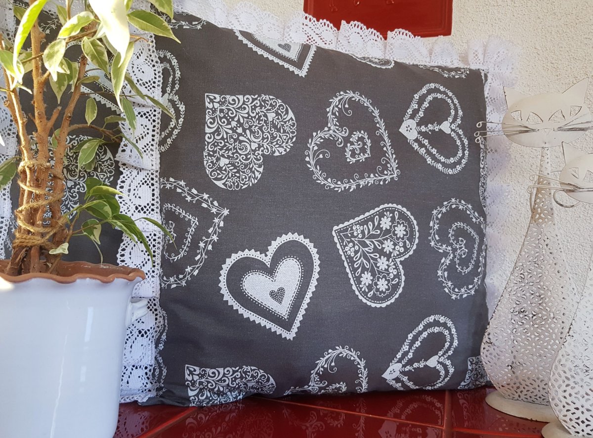 Vánoční polštář s motivem bílých srdíček, lemovaný krajkou šíře 45 mm, včetně výplně.