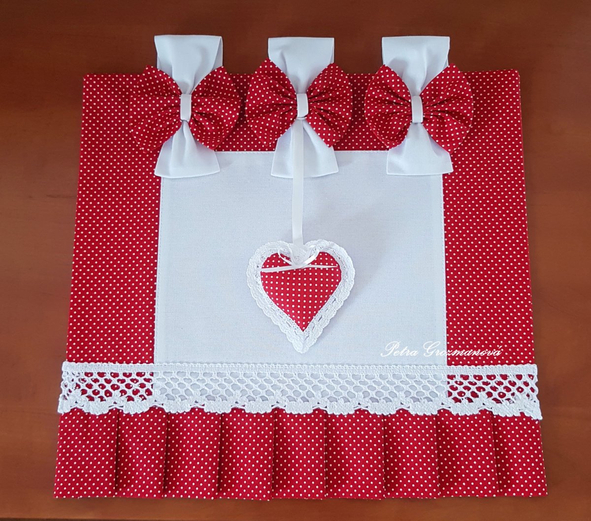 Závěs na troubu v červeném provedení s motivem bílých puntíků, lemovaný bílou krajkou šíře 45 mm