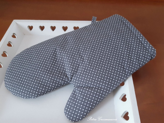 Kuchyňská rukavice v šedém provedení s motivem bílých puntíků na zavěšení.