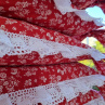 Běhoun v červeném provedení s motivem folkloru, lemovaný bílou krajkou šíře 45 mm