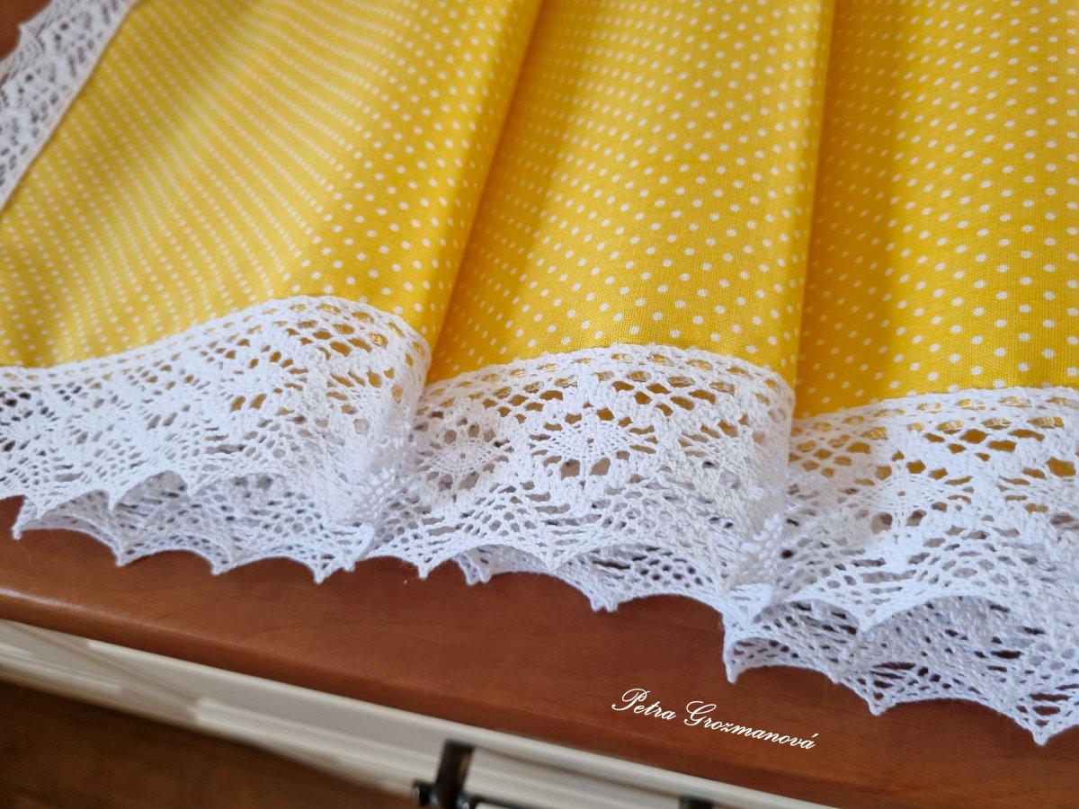 Běhoun ve žlutém provedení s motivem bílých puntíků, lemovaný bílou krajkou šíře 45 mm