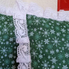 Sedák s vánočním motivem, lemovaný krajkou šíře 45 mm včetně výplně s úvazy.