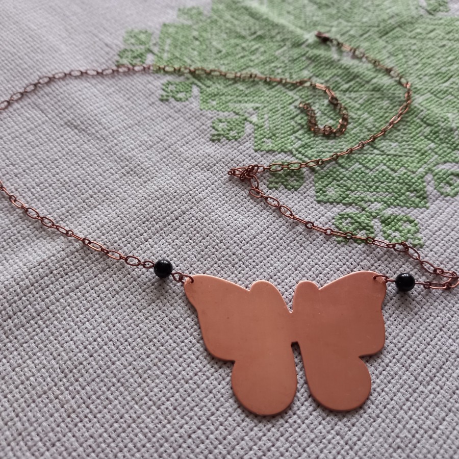 Měděný motýl s onyxovými korálky