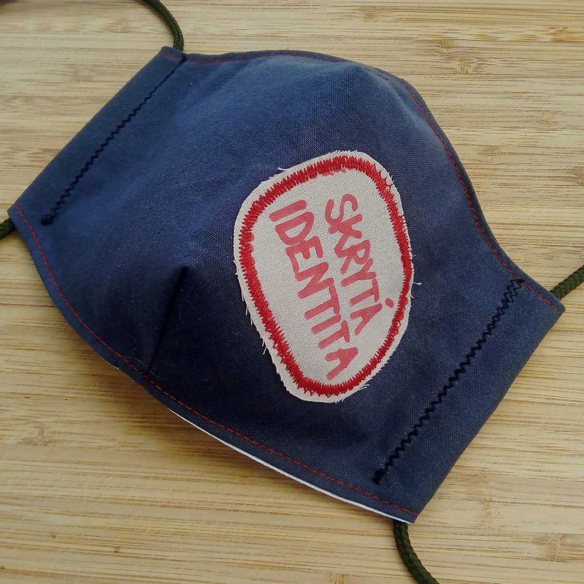 Šedá rouška s nápisem Skrytá identita