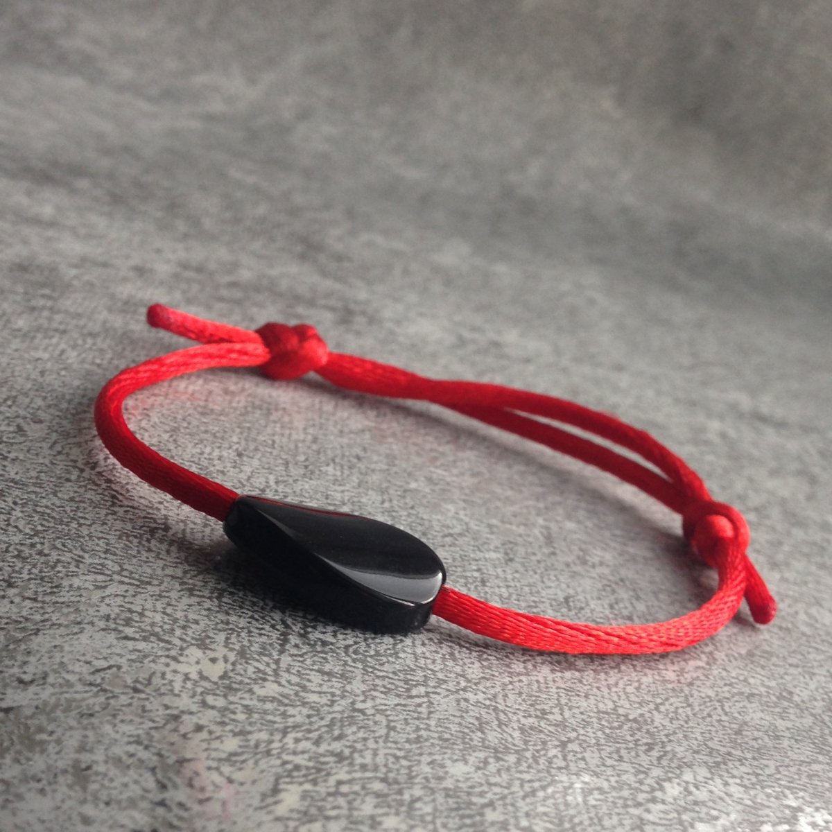 Červený náramek s černým korálkem