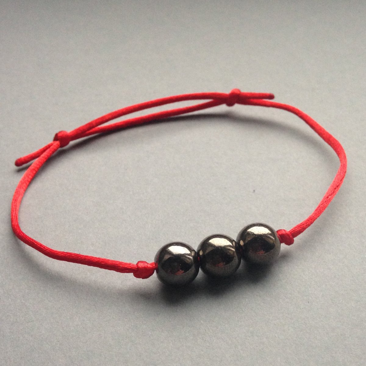 Červený náramek se třemi kuličkami