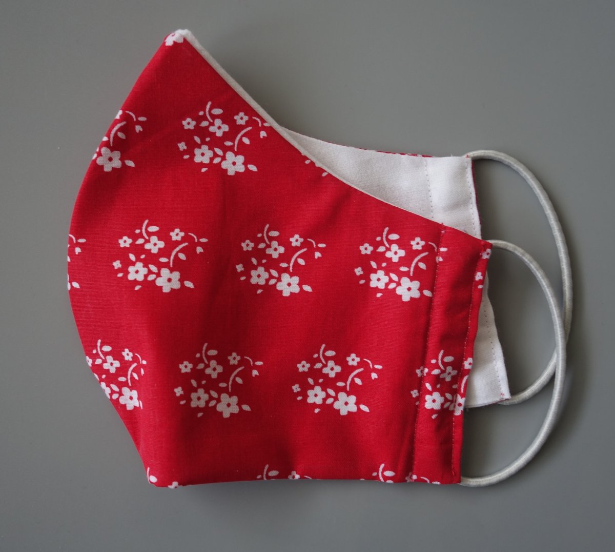 Bavlněná rouška dvouvrstvá bílé kytičky na červené