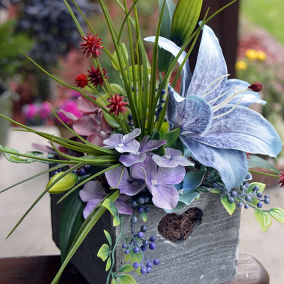 lilie a hortenzie v dřevěném truhlíku..