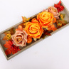 Oranžové a skořicové růže na dřevěném tácu