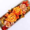 Oranžové a skořicové růže na dřevěném tácu