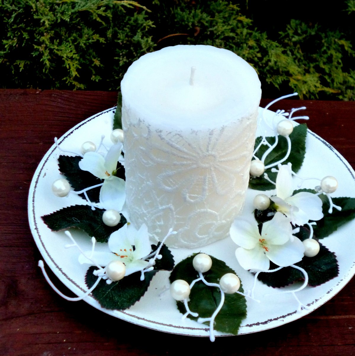 Svícen na dřevěném tácku s bílou krajkovou svící