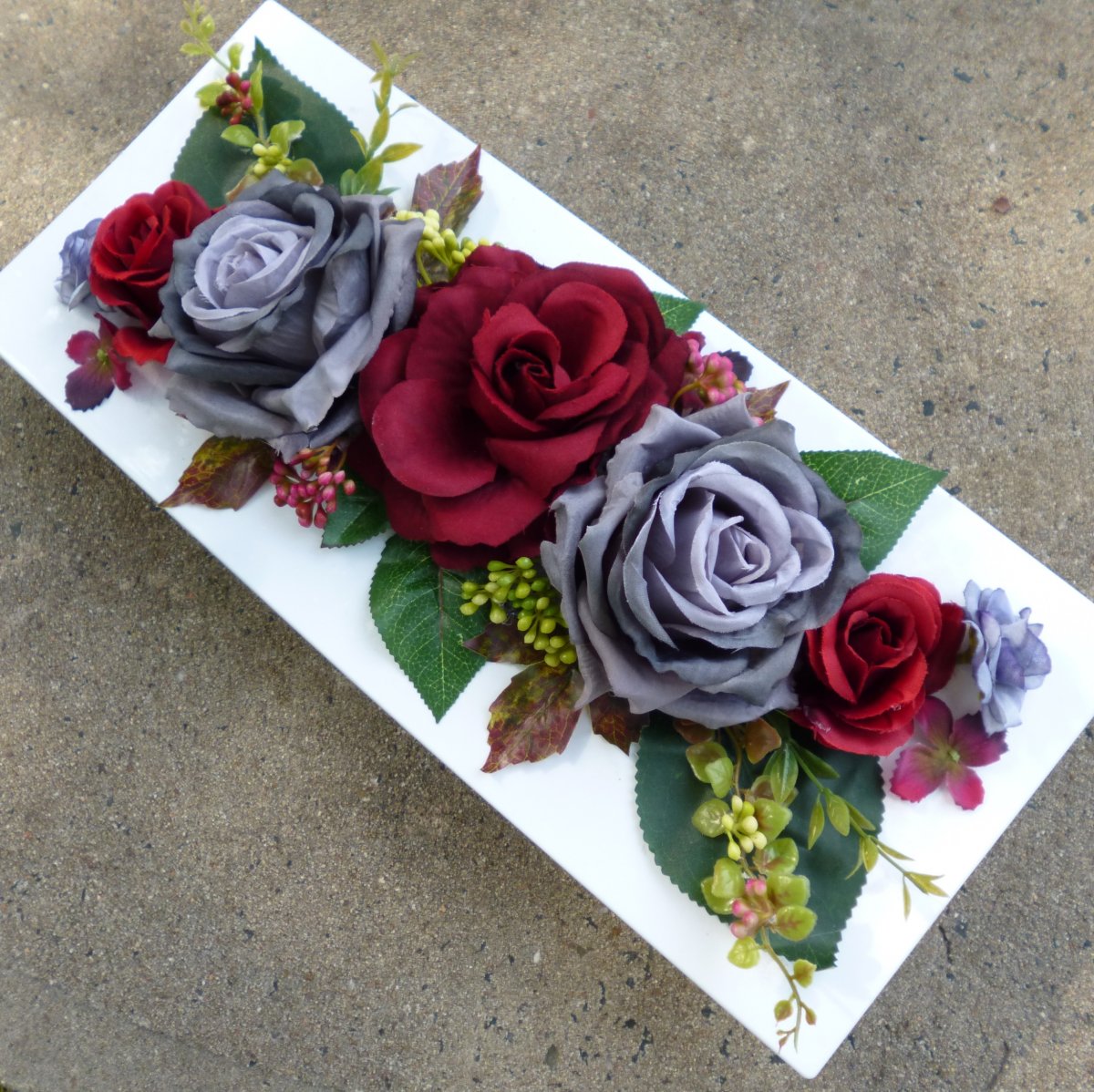 Vínové a šedé růže na bílé lesklé plastové misce