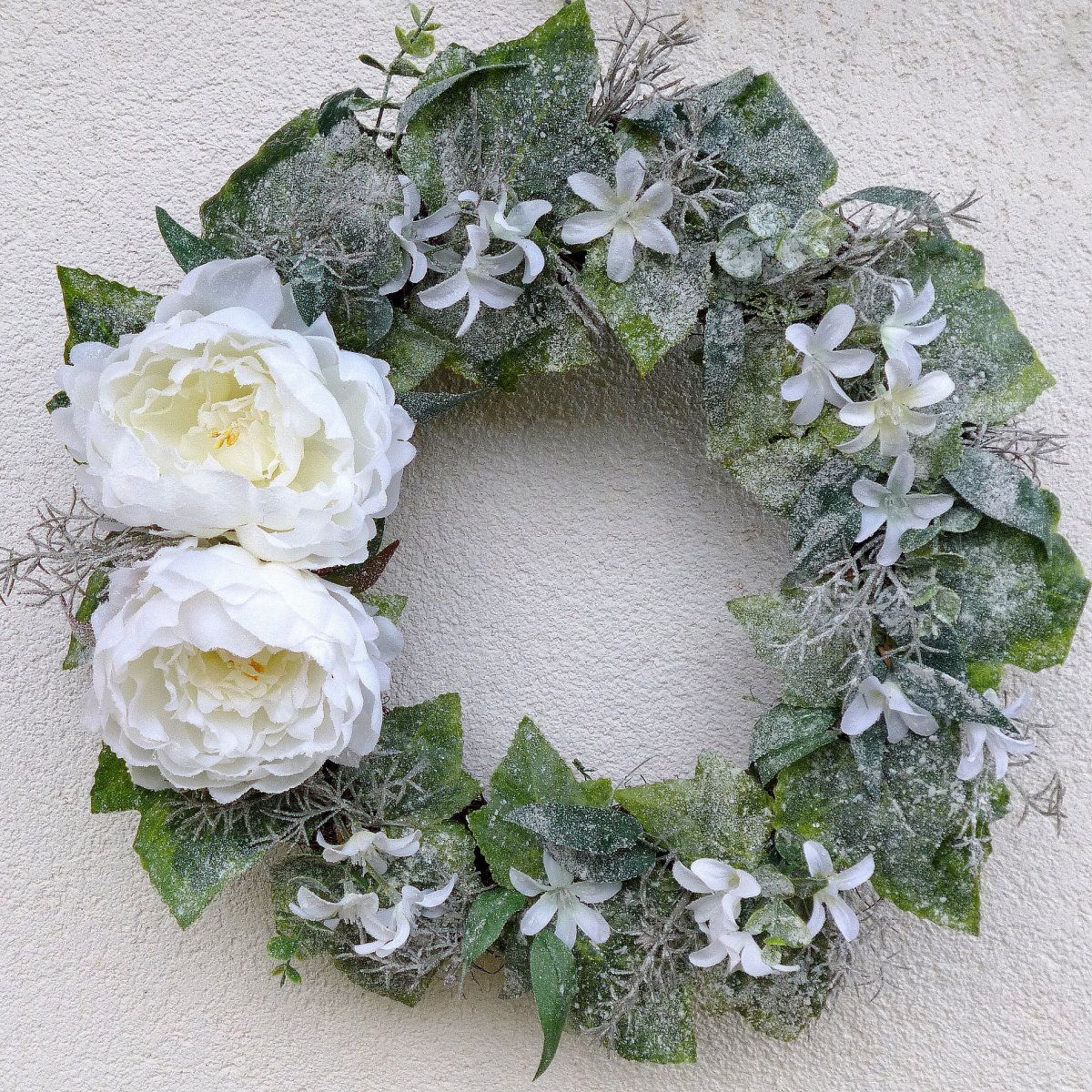Velký zasněžený věnec s bílými pivoňkami a vistárií