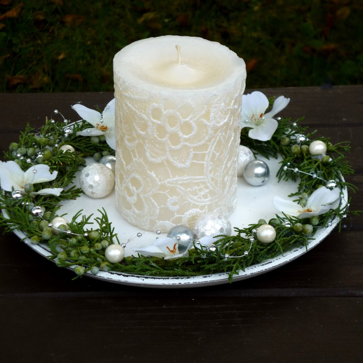 Svícen na dřevěném tácku s bílou krajkovou svící