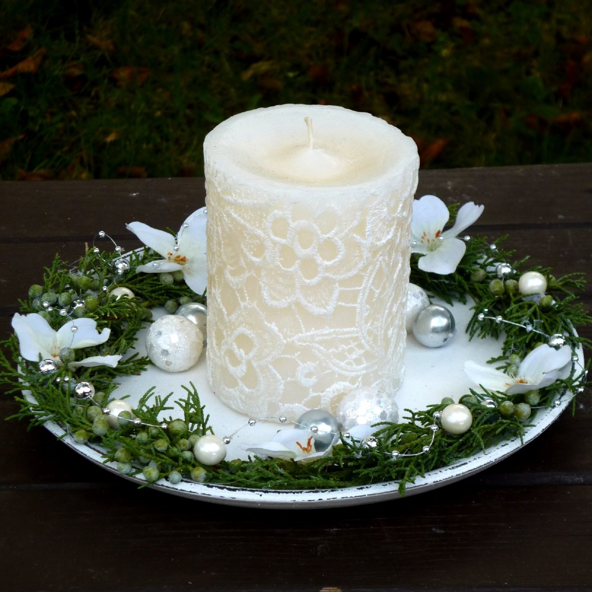 Svícen na dřevěném tácku s bílou krajkovou svící