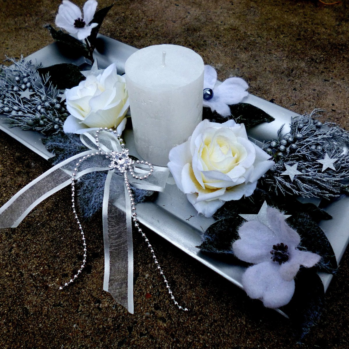 Vánoční svícen s jalovcem a bílou svící na metalickém tácu