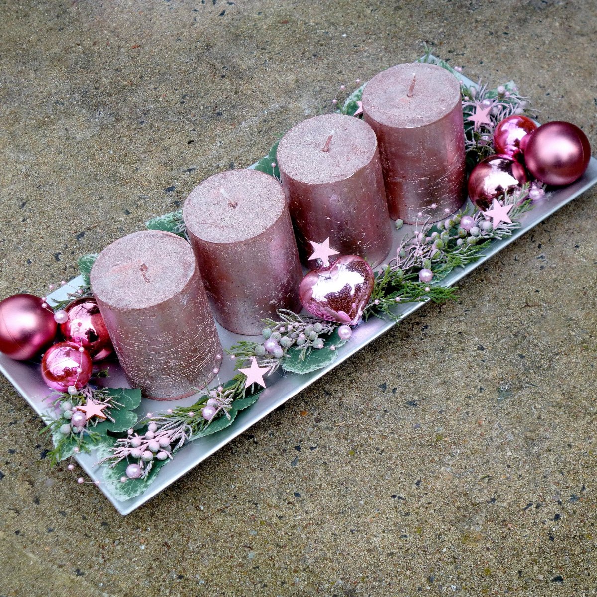 Adventní svícen s růžovými ojíněnými svícemi na metalickém tácu