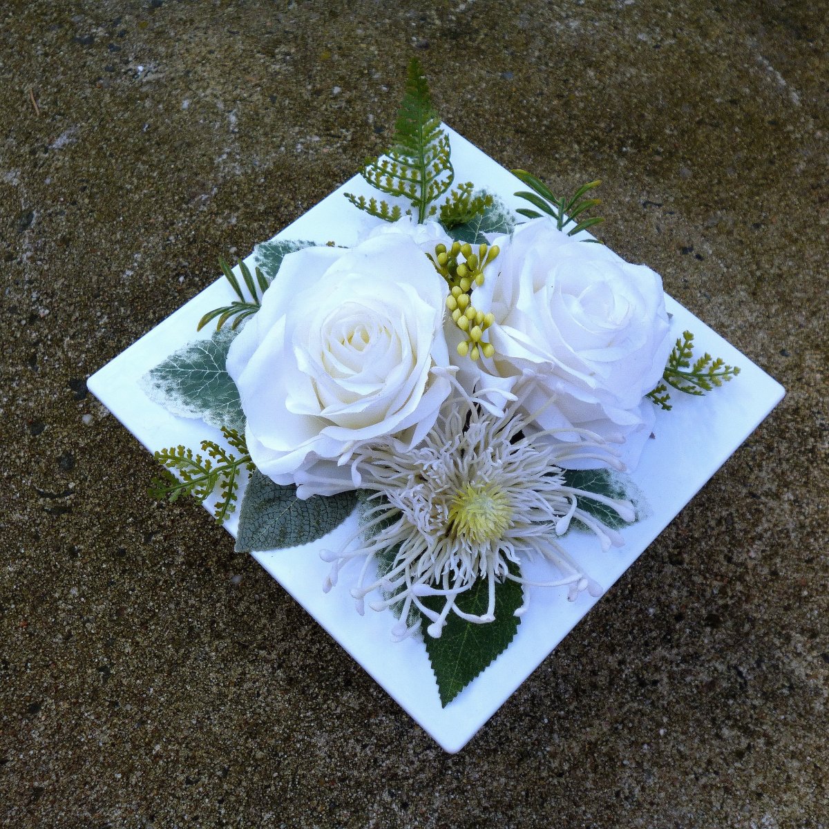 Aranžmá na stůl s bílými růžemi na bílé lesklé misce