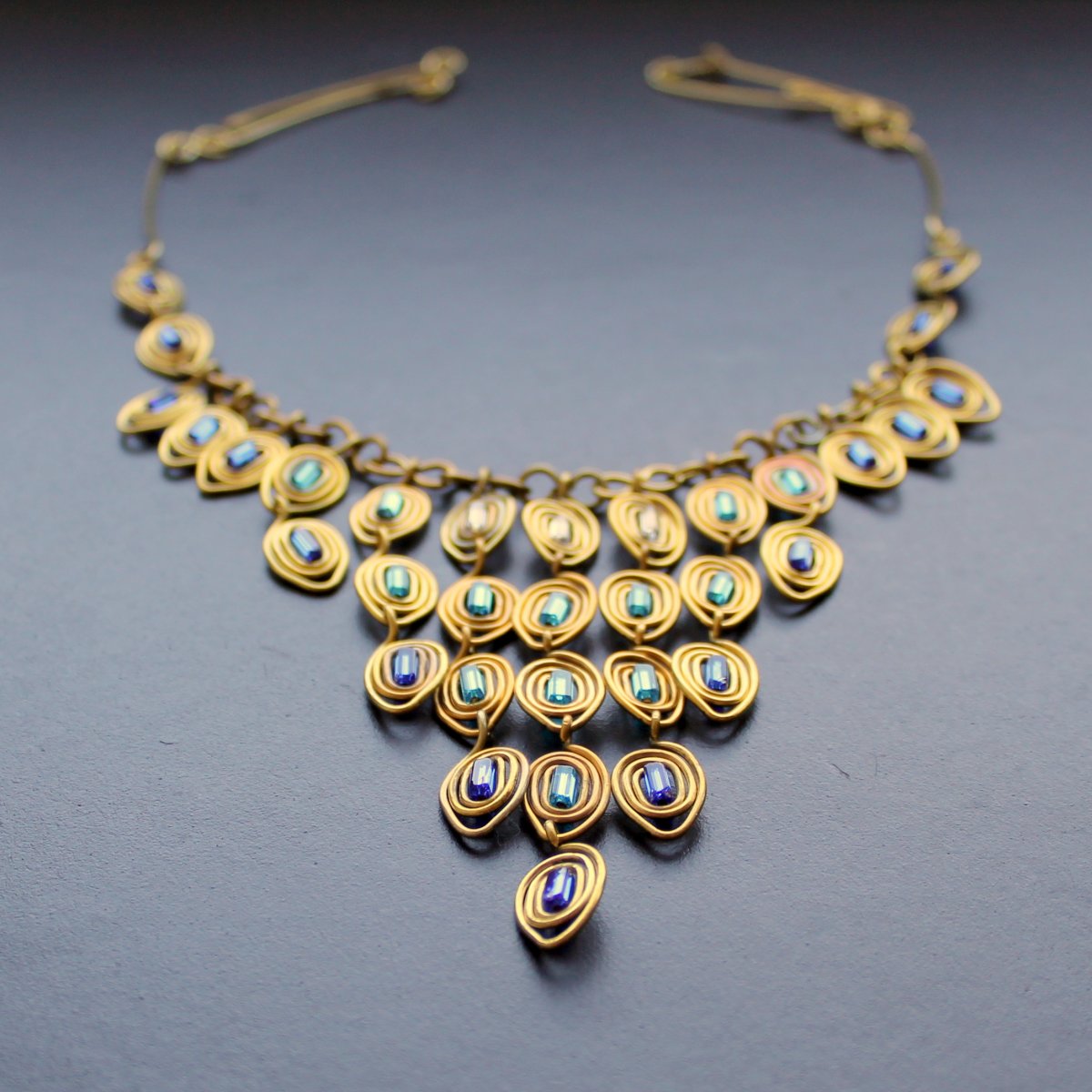 Paví v mosazi v modré