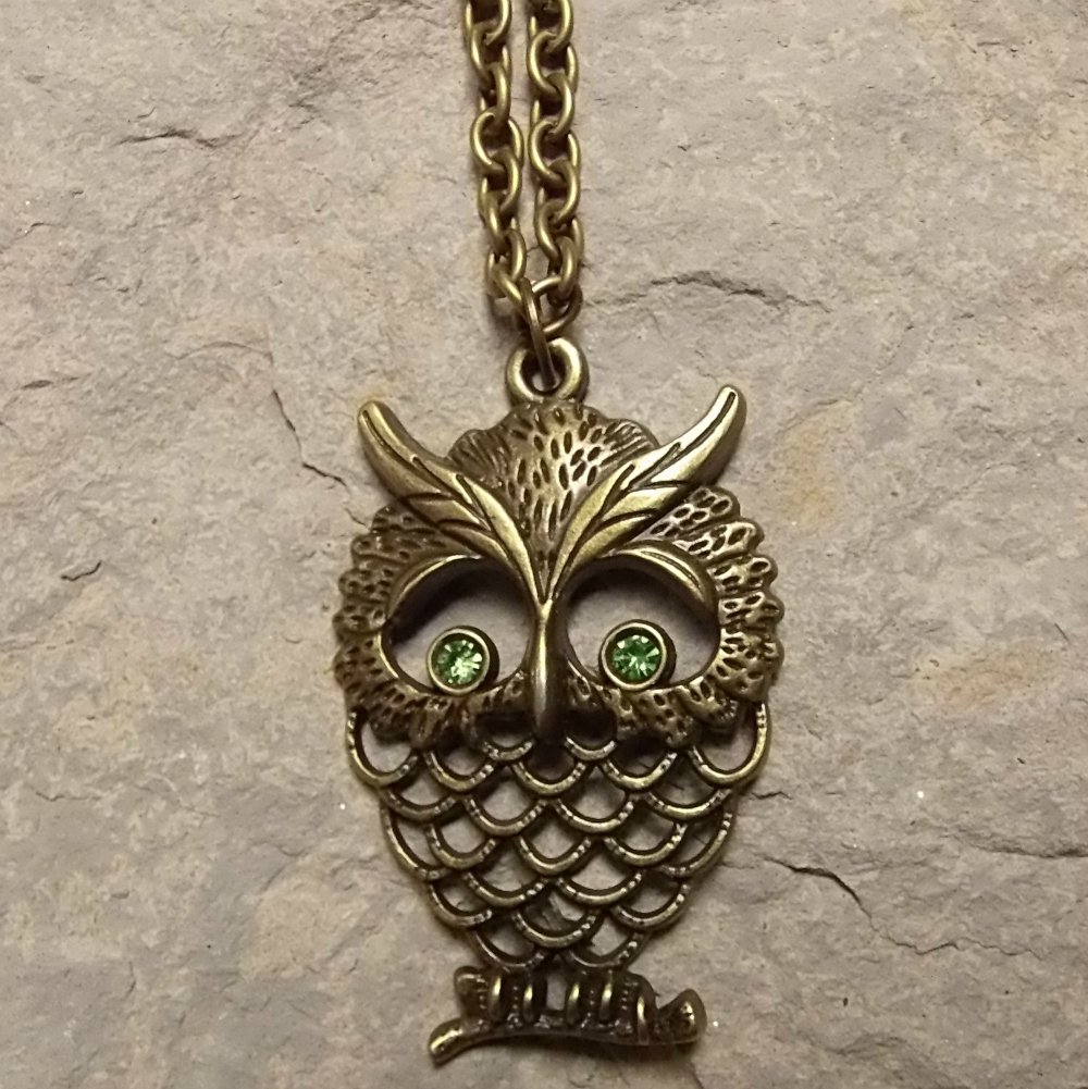 Bronzová sova se zelenýma očima