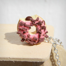 Růžový donut nakousnutý, s čoko posypkou